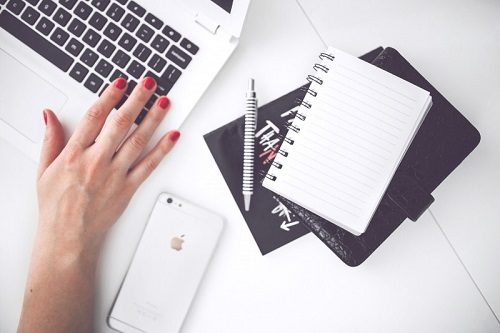 woman-working-on-laptop-with-notebook-and-mobile-phone-on-table.jpg