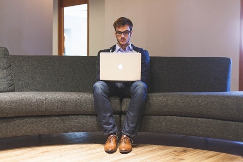 man-sitting-on-sofa-and-using-computer.jpg