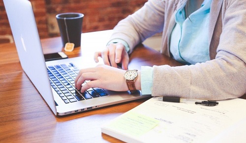 woman-sitting-at-table-and-using-laptop-with-tea-cup-in-background.jpg