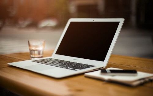 laptop-mobile-phone-and-water-glass-on-wooden-table.jpg